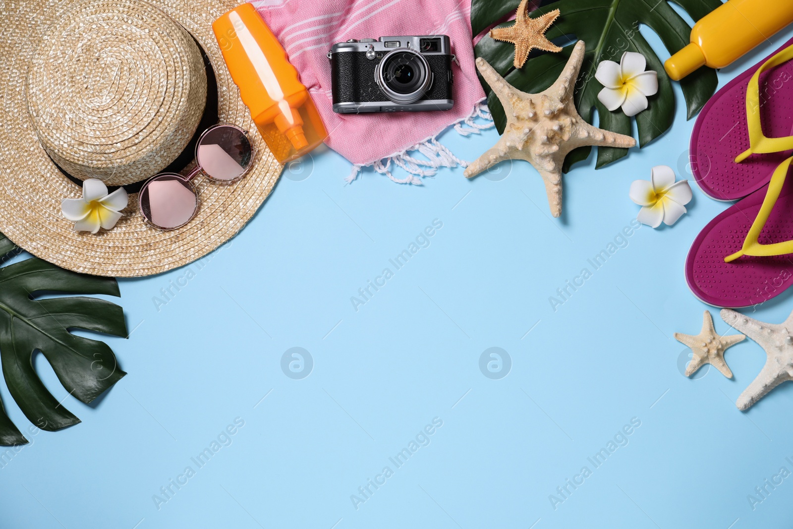 Photo of Flat lay composition with beach items on light blue background. Space for text