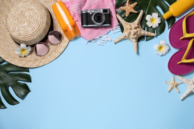 Photo of Flat lay composition with beach items on light blue background. Space for text