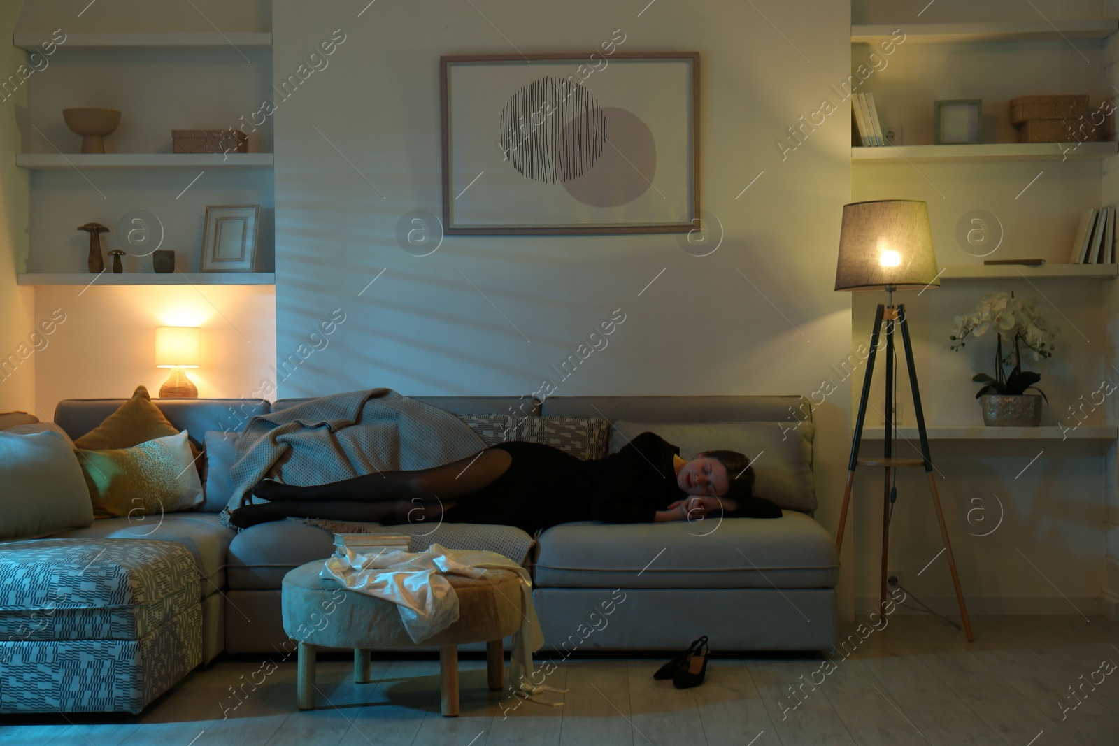 Photo of Woman resting on couch in room at night