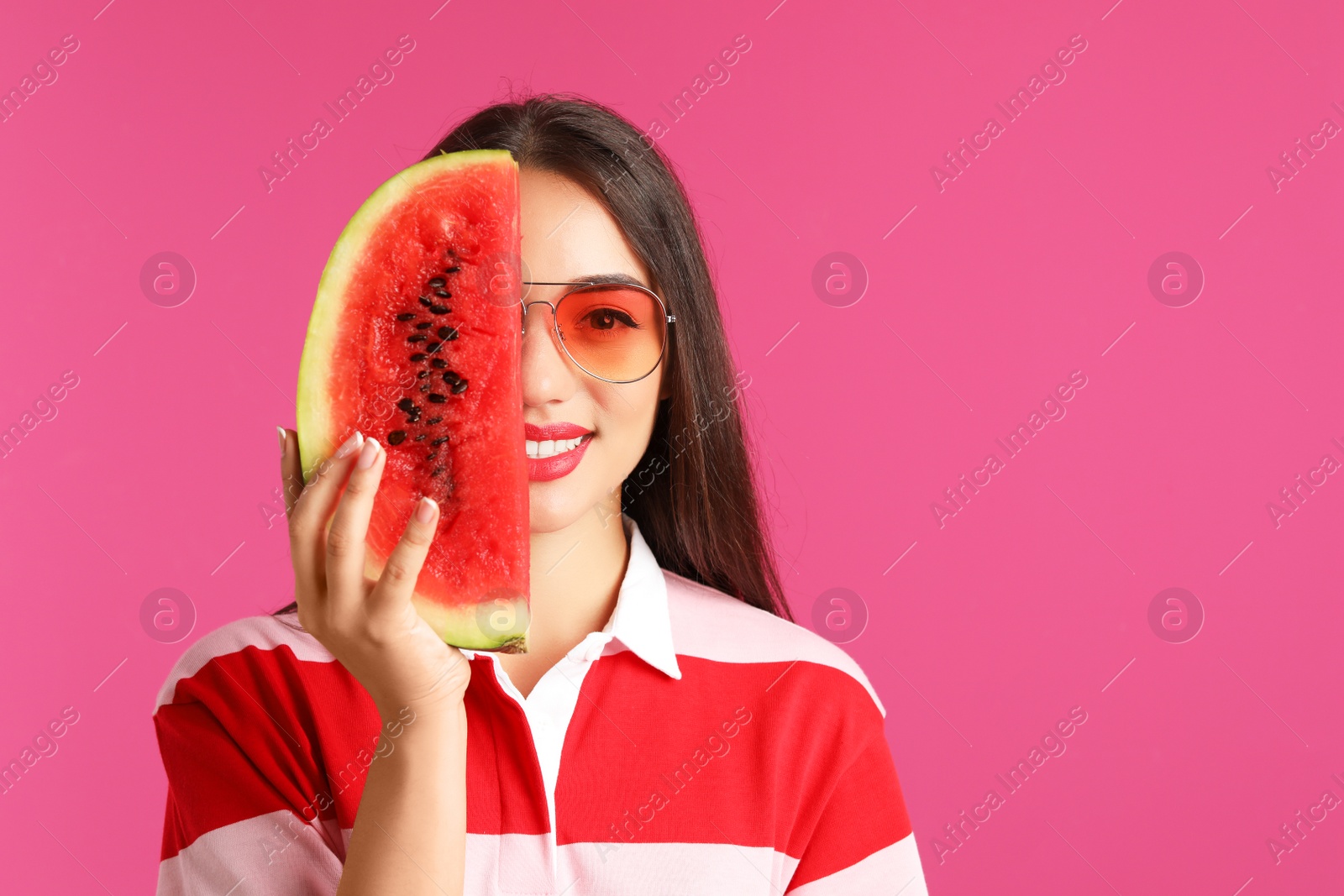 Photo of Beautiful young woman posing with watermelon on color background