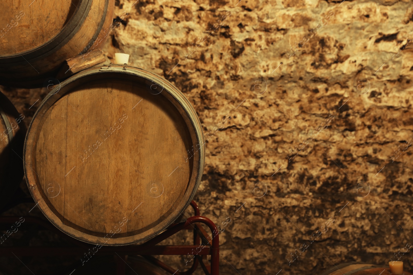 Photo of Wooden wine barrels near stone wall with space for text