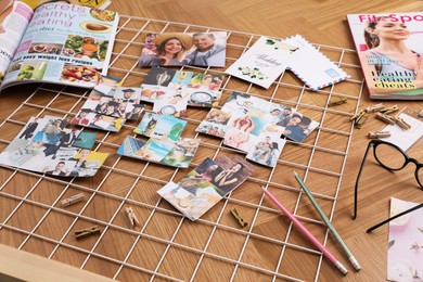 Composition with different photos, magazines, stationery and metal grid on wooden background. Creating vision board