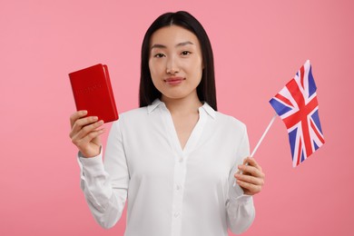 Photo of Immigration to United Kingdom. Woman with passport and flag on pink background