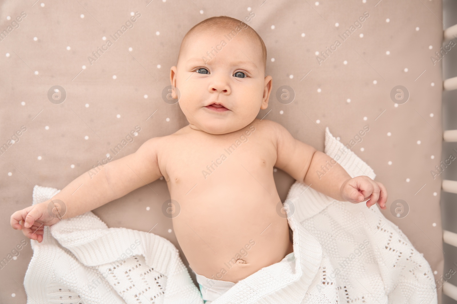 Photo of Adorable baby girl lying in bed, top view