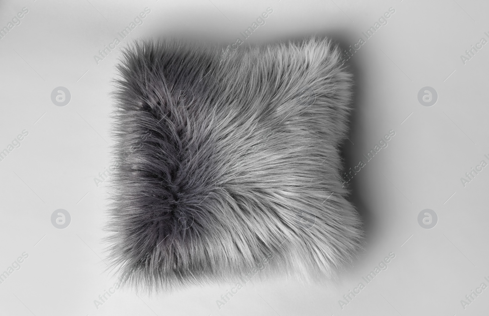 Photo of Fluffy decorative pillow on light background