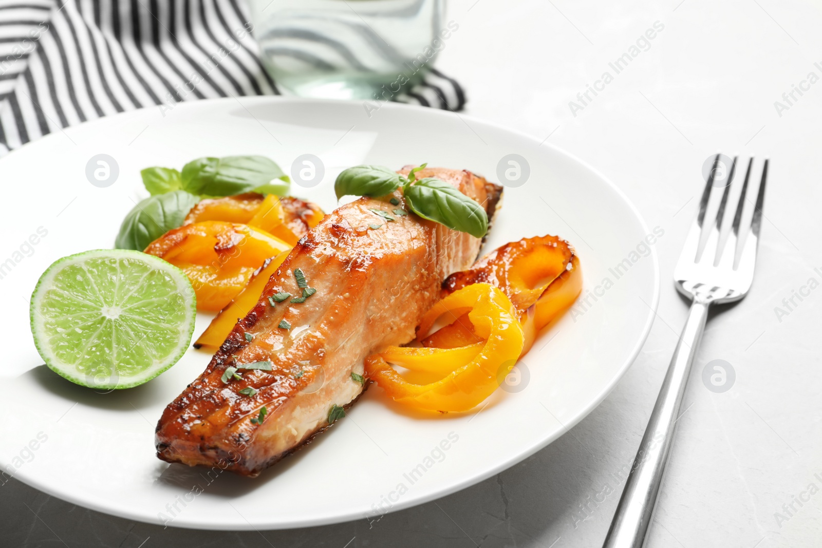 Photo of Tasty cooked salmon with vegetables on plate, closeup