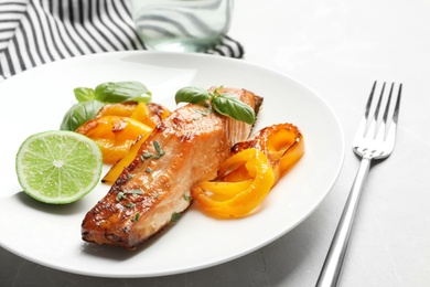 Photo of Tasty cooked salmon with vegetables on plate, closeup