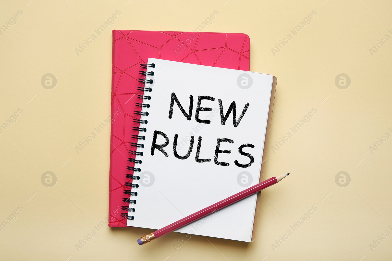 Image of Office stationery with text NEW RULES on beige background, flat lay