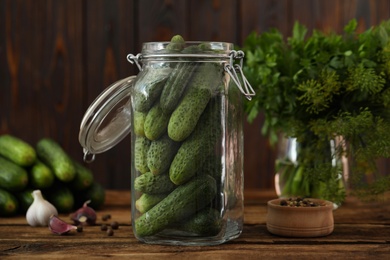 Photo of Pickling jar with fresh cucumbers on wooden table