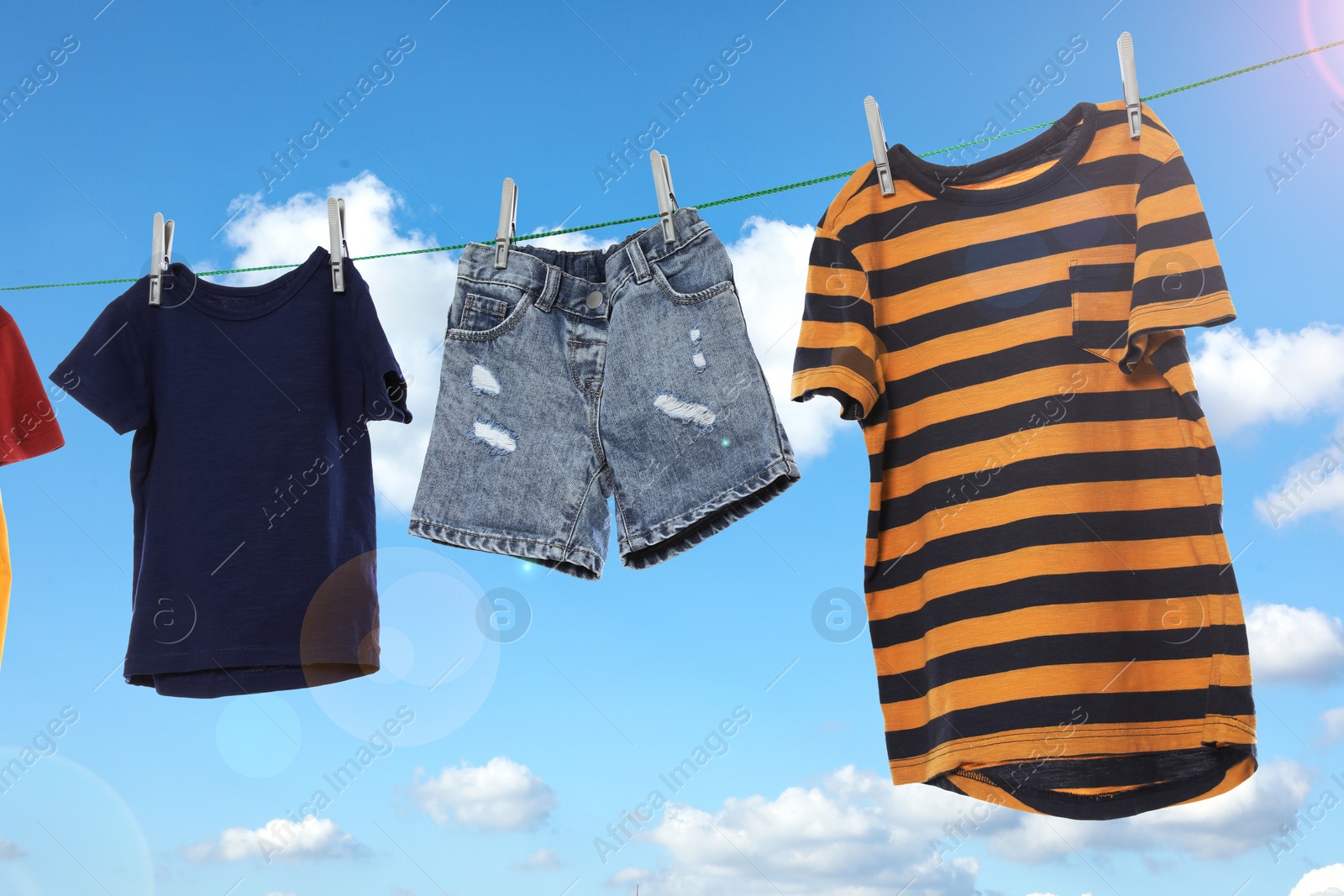 Image of Different clothes drying on washing line against sky