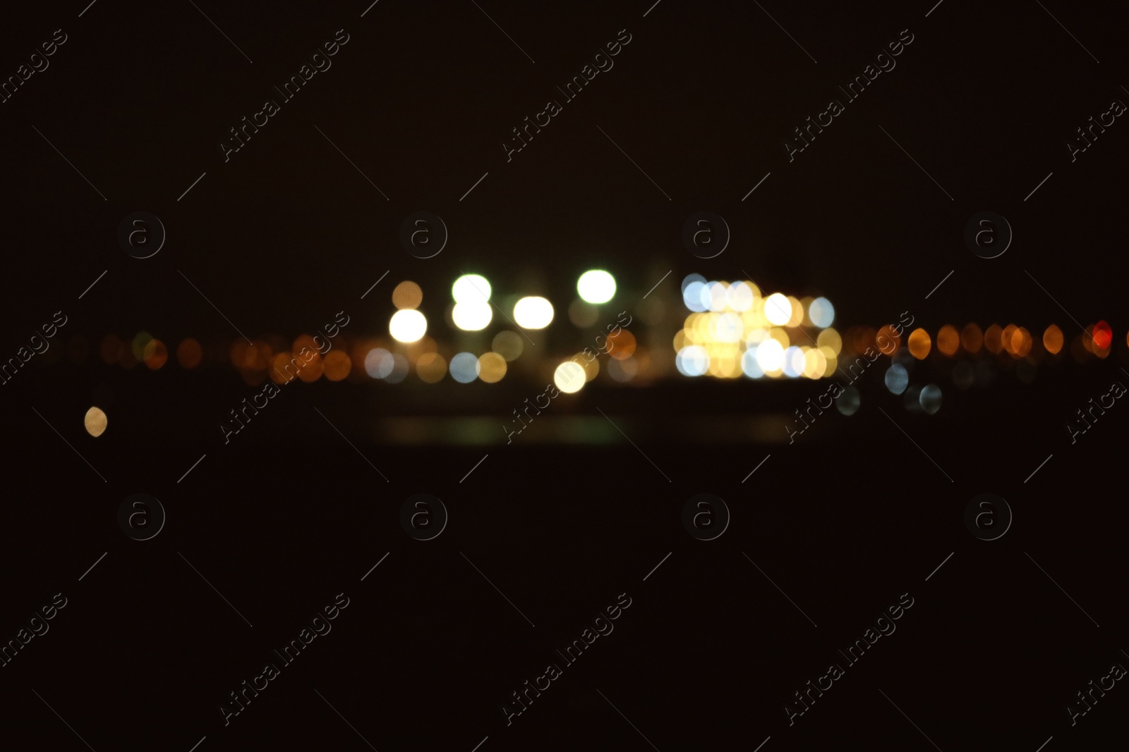 Photo of Blurred view of bulk carrier in roads at night. Bokeh effect