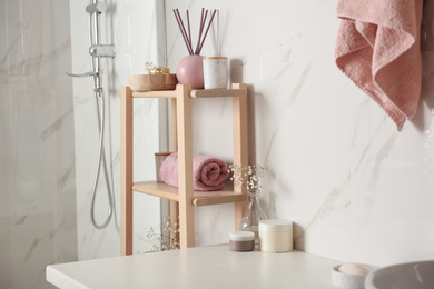 Photo of Shelving unit with clean towel in bathroom interior