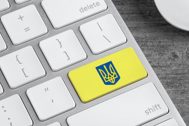 Yellow button with Ukrainian coat of arms on keyboard, closeup view