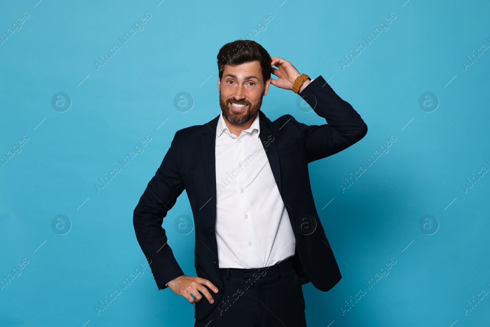 Photo of Portrait of smiling bearded man in suit on light blue background