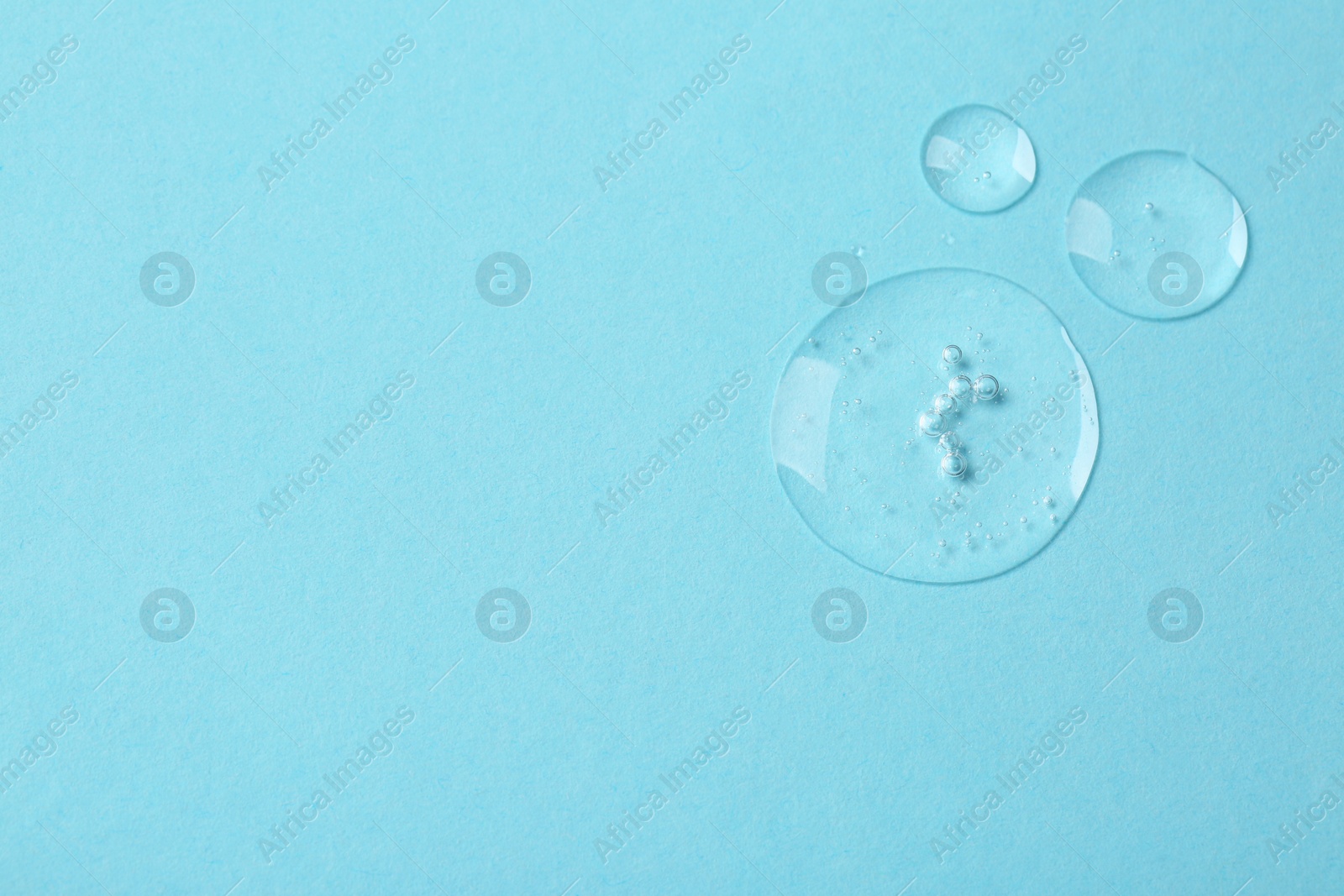 Photo of Samples of cosmetic serum on light blue background, flat lay. Space for text
