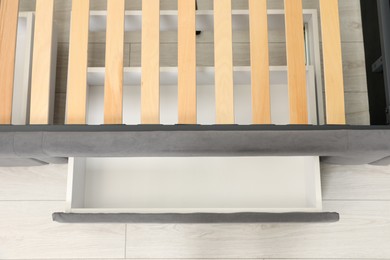 Storage drawer for bedding under modern bed in room, above view