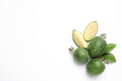 Photo of Cut and whole feijoas with leaves on white background, top view