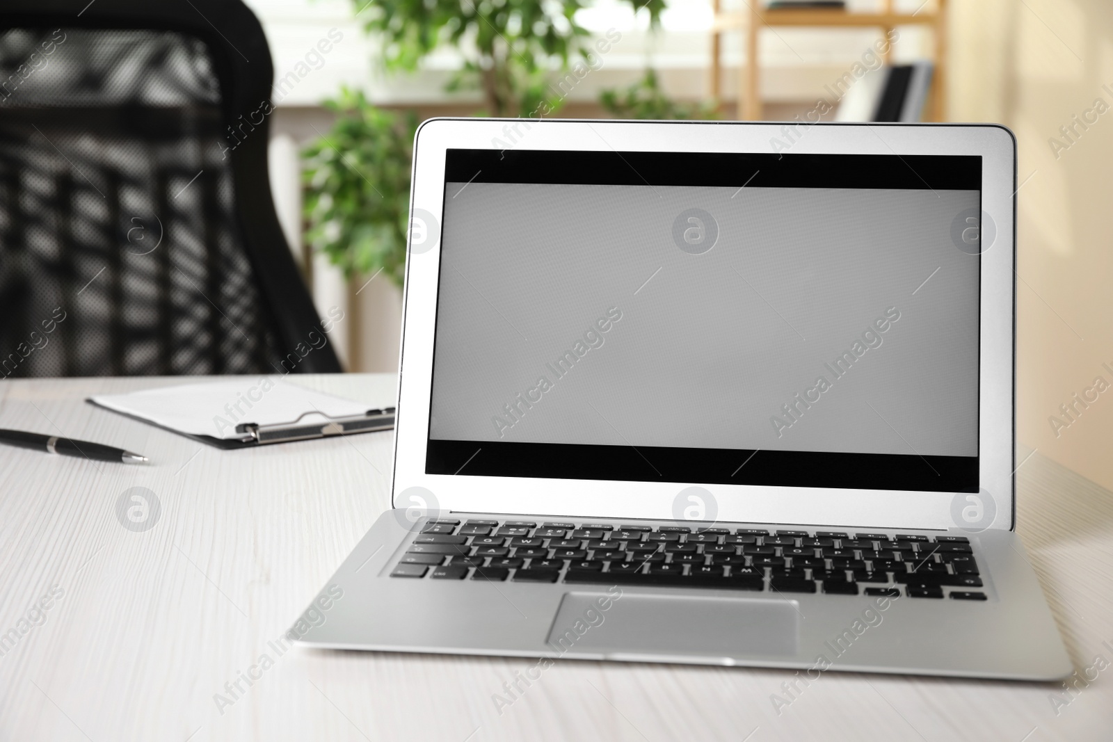Photo of Modern laptop on white wooden table in office
