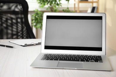 Modern laptop on white wooden table in office