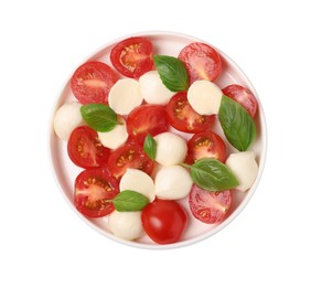Plate of delicious Caprese salad with tomatoes, mozzarella and basil isolated on white, top view