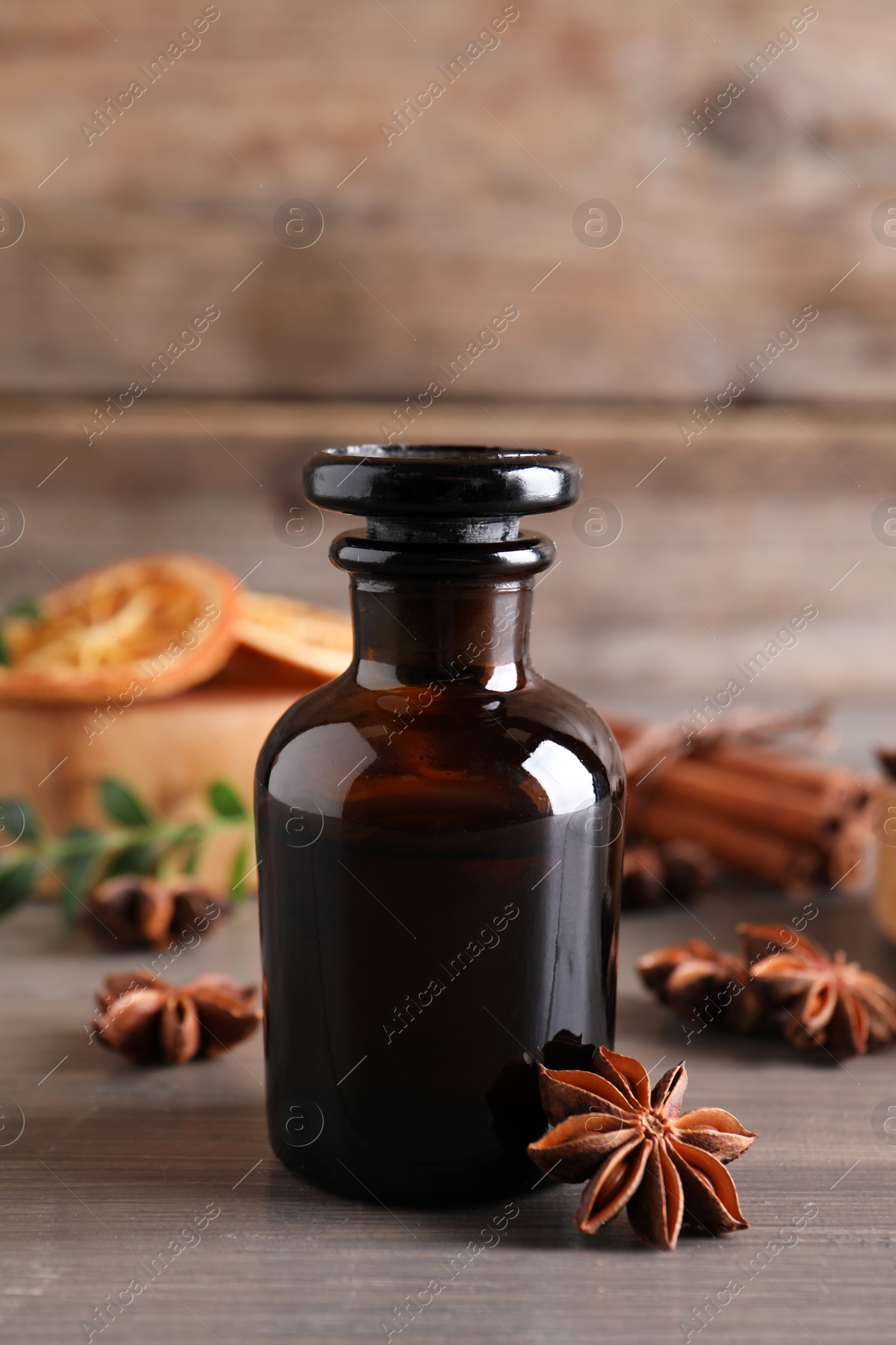 Photo of Anise essential oil and spice on wooden table