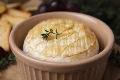 Tasty baked camembert in bowl on table, closeup