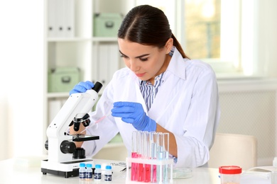 Photo of Female scientist working at table in laboratory. Research and analysis