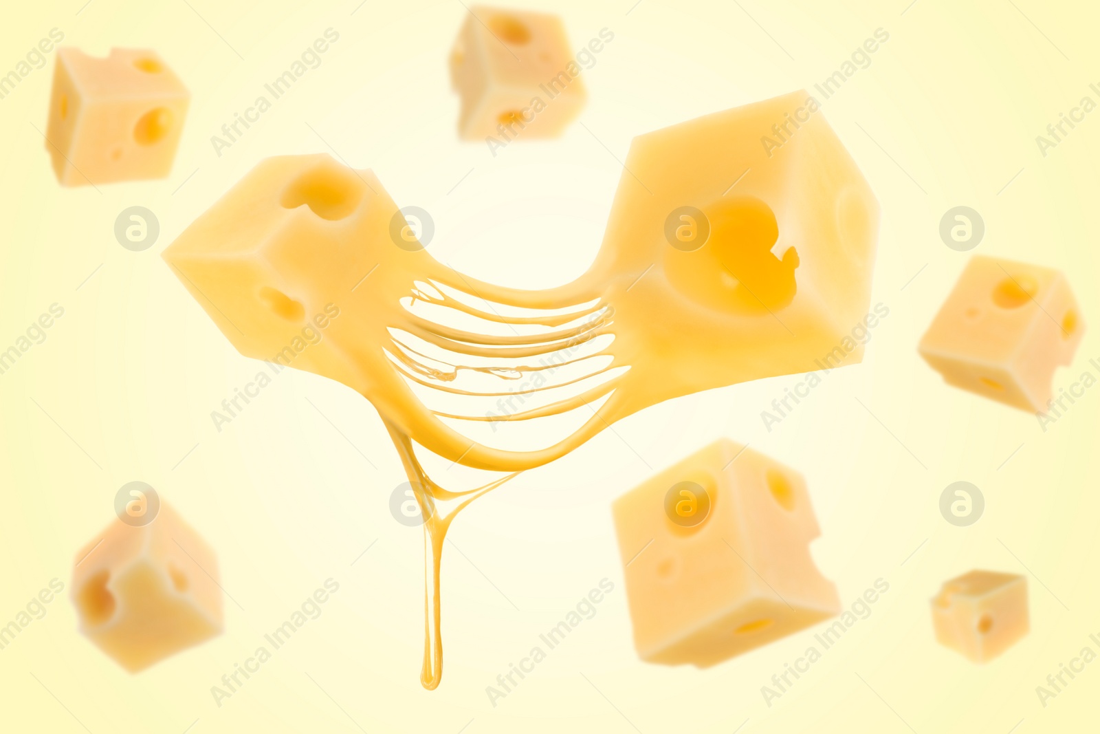 Image of Pieces of cheese falling on yellow background