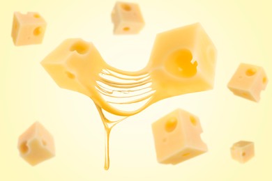 Pieces of cheese falling on yellow background