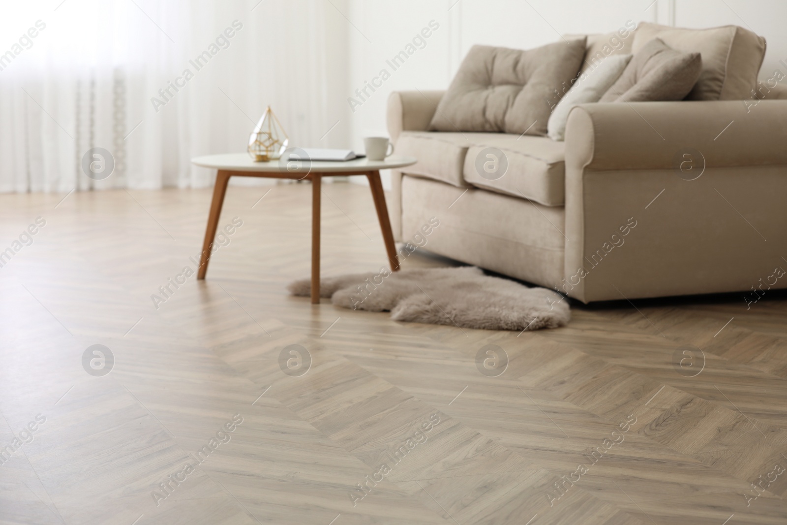 Photo of Parquet floor in room with sofa and coffee table