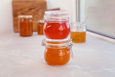 Photo of Jars with different sweet jam on windowsill