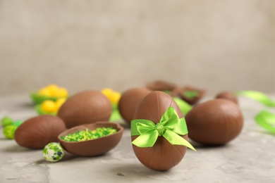 Photo of Sweet chocolate eggs on grey marble table. Space for text