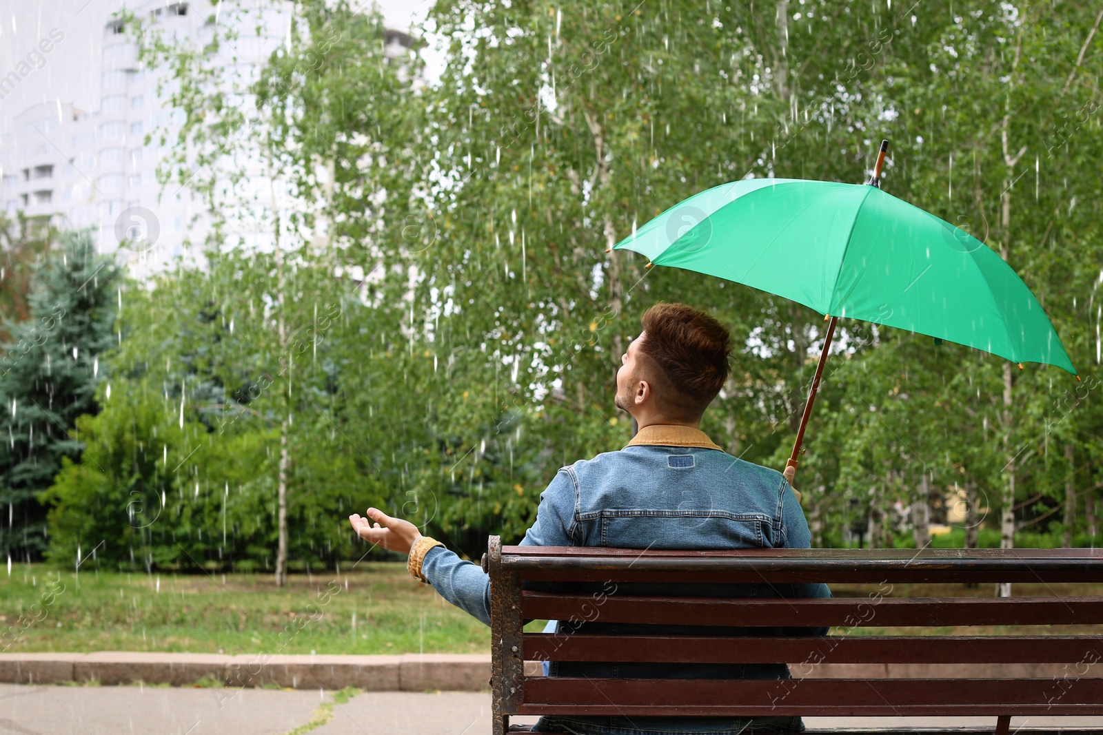 Photo of Man with umbrella outdoors on rainy day