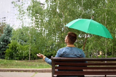 Man with umbrella outdoors on rainy day