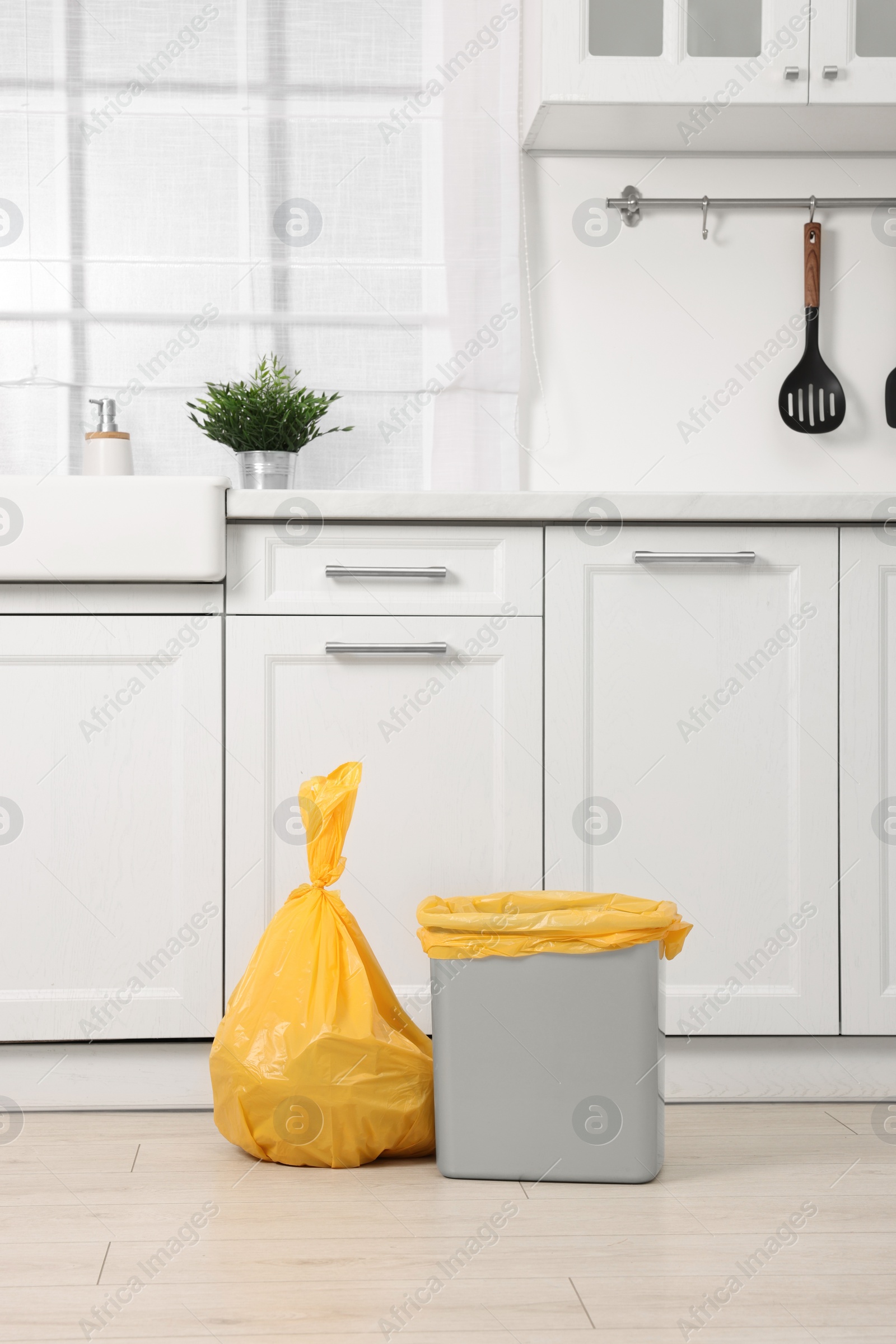 Photo of Plastic garbage bag and trash can in kitchen