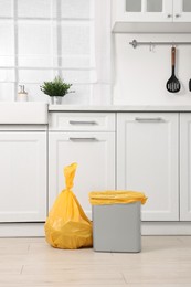 Photo of Plastic garbage bag and trash can in kitchen