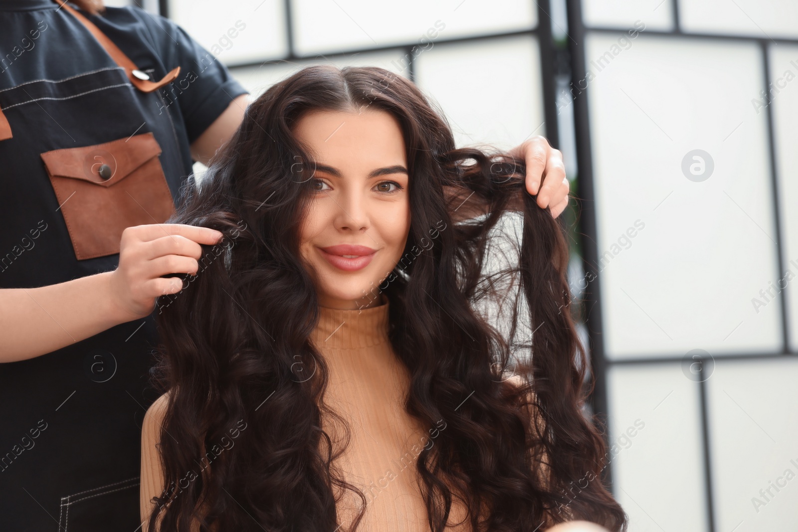 Photo of Hair styling. Professional hairdresser working with client in salon, closeup. Space for text