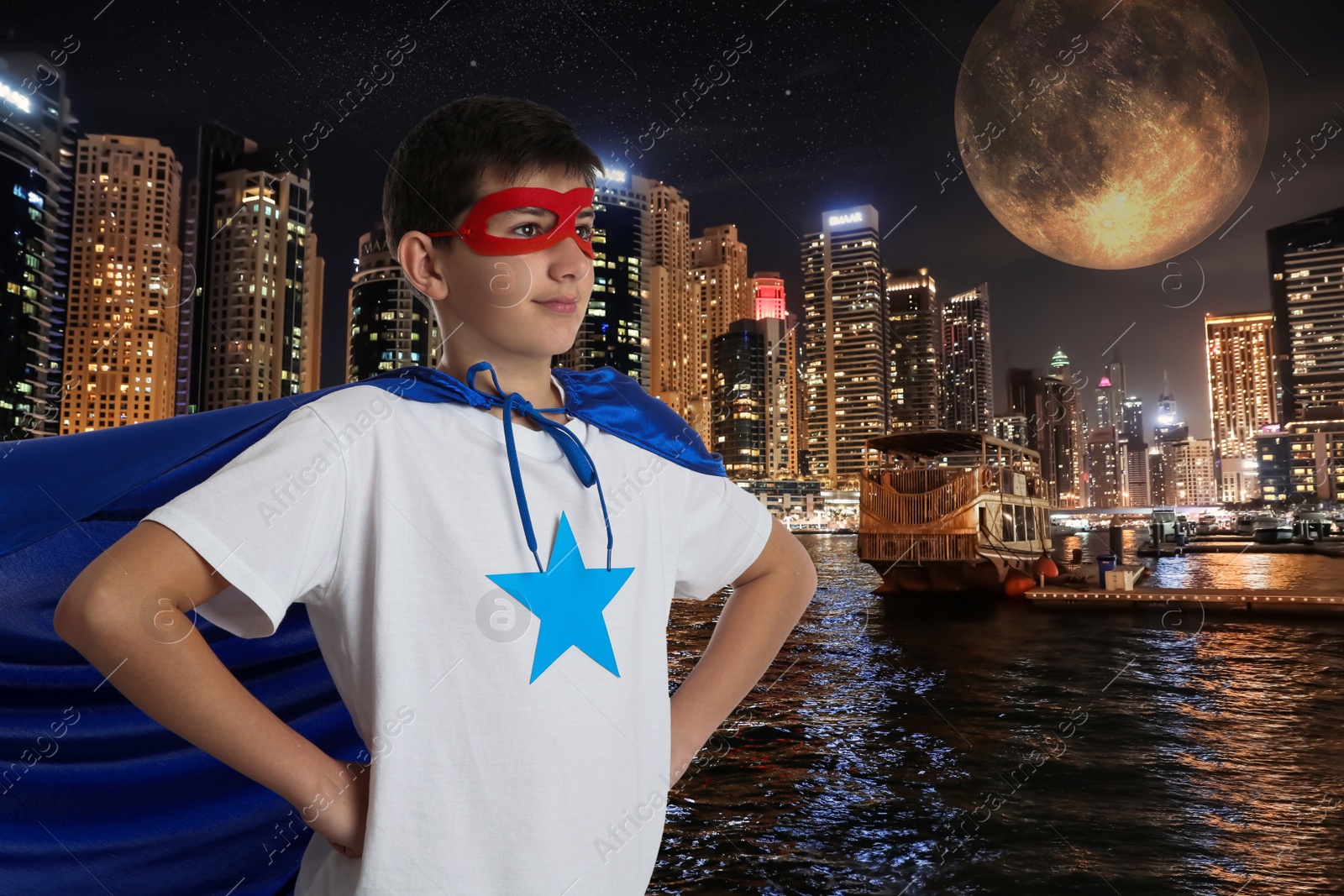 Image of Teenage boy wearing superhero costume and beautiful cityscape in night on background