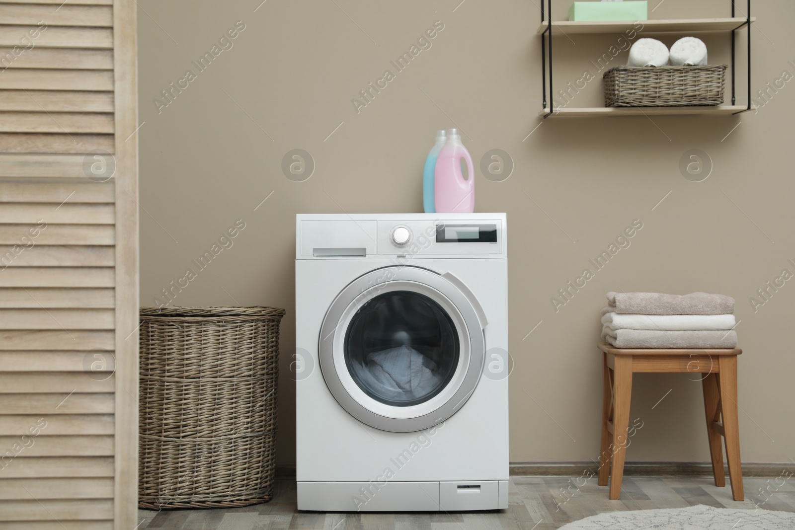 Photo of Washing machine with dirty towel in laundry room