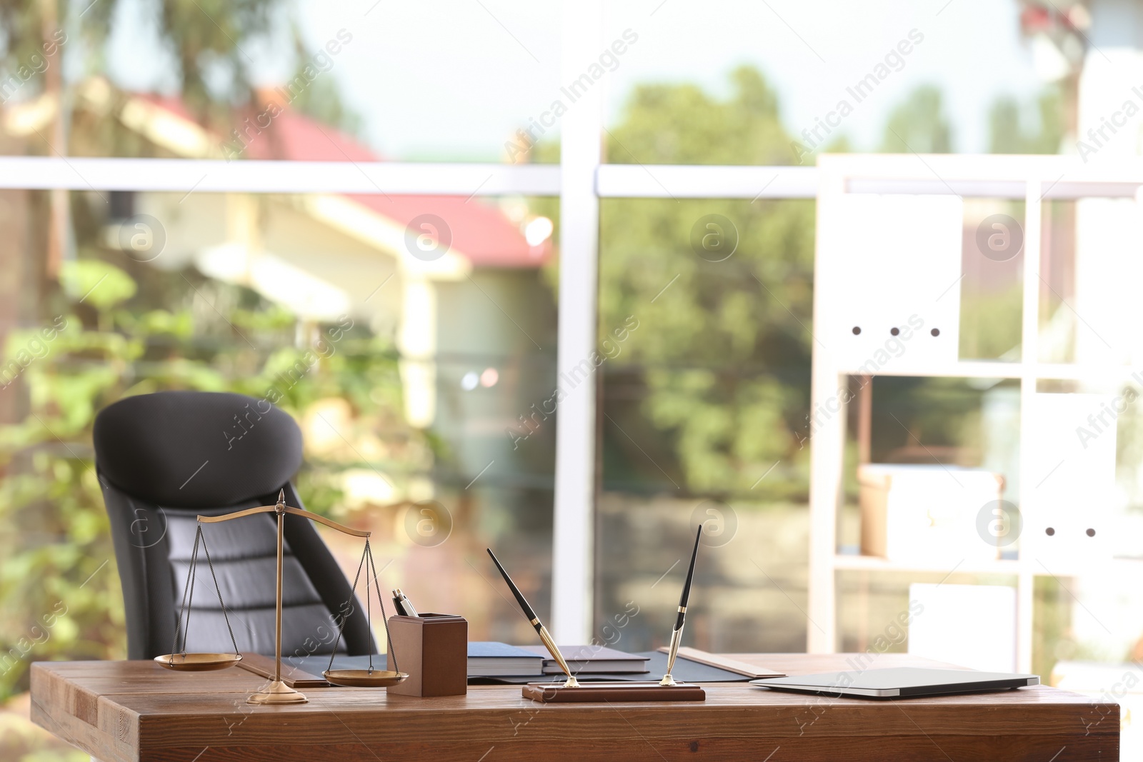 Photo of Table with scales of justice in lawyer's office