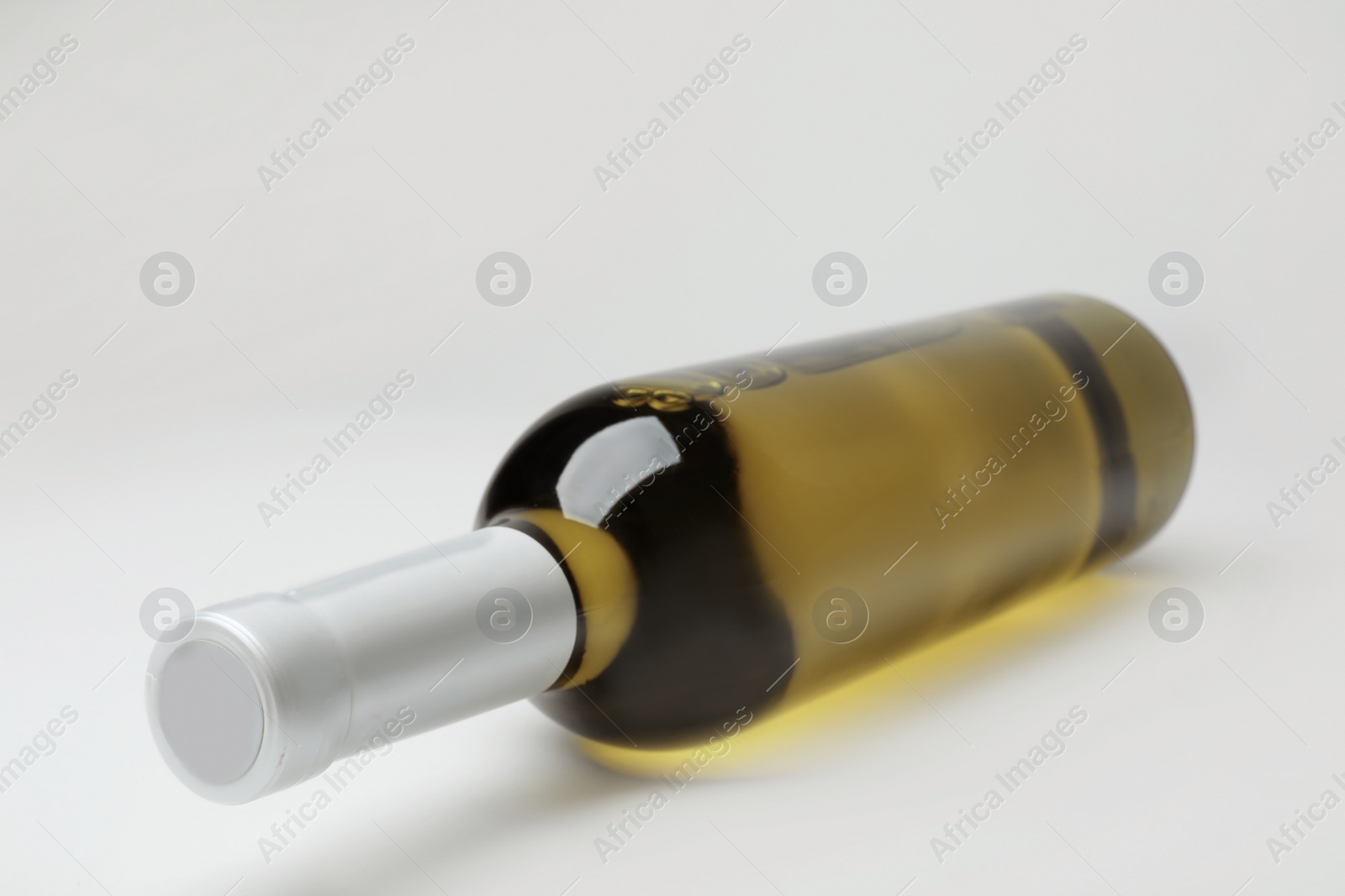 Photo of Bottle of expensive white wine on light background