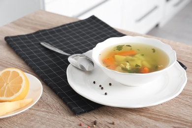 Photo of Bowl with delicious hot broth on table. Cold treatment