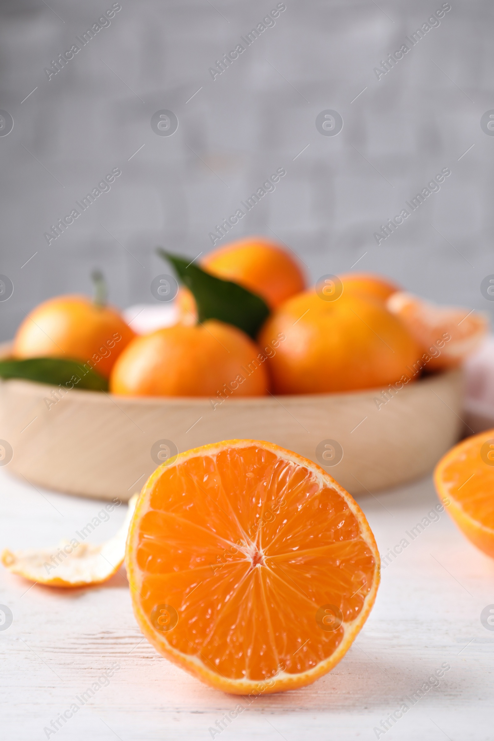 Photo of Cut fresh ripe tangerines on white wooden table