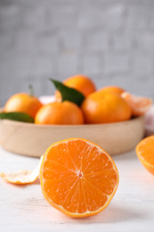 Photo of Cut fresh ripe tangerines on white wooden table