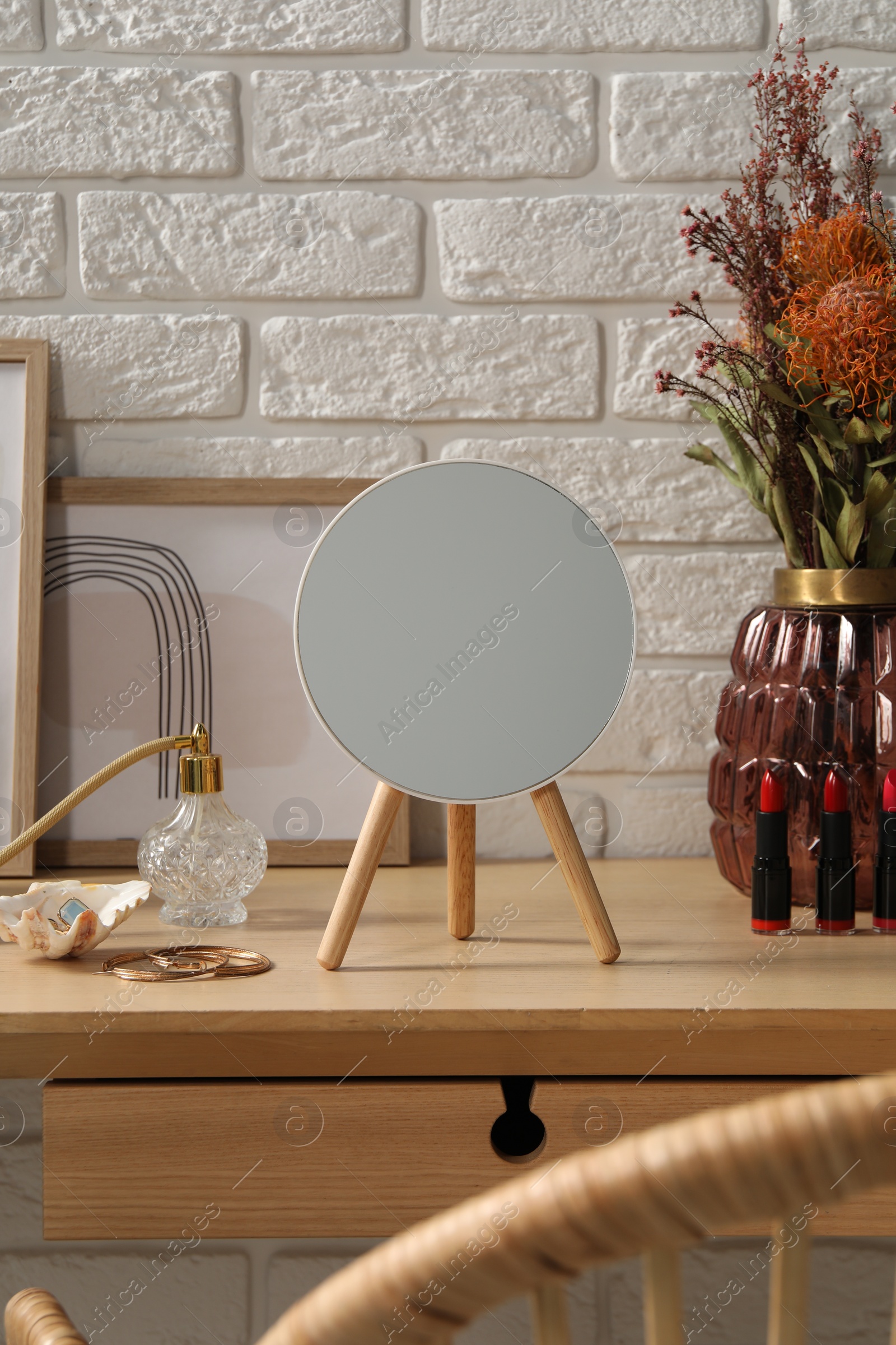 Photo of Mirror, jewelry and perfume on dressing table in makeup room
