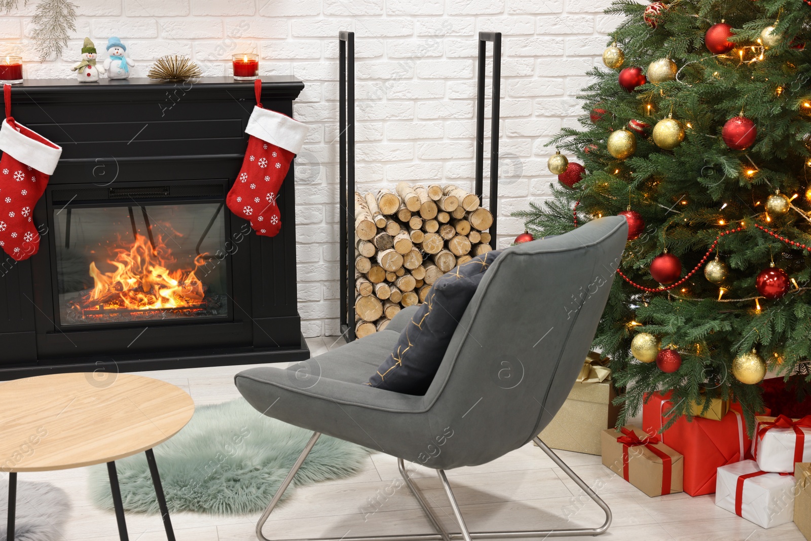 Photo of Beautiful Christmas tree near fireplace and cosy armchair in room. Interior design