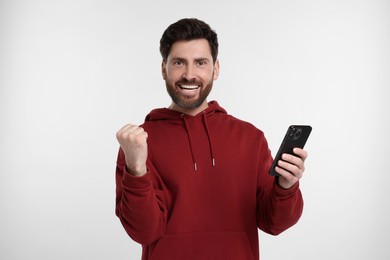 Photo of Happy man with smartphone on white background