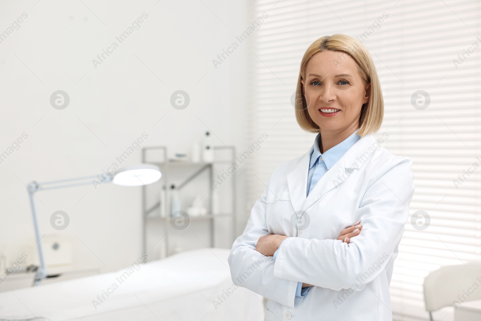 Photo of Portrait of happy dermatologist in modern clinic, space for text