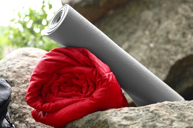 Rolled sleeping bag and mat on rock