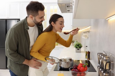 Photo of Lovely young couple cooking together in kitchen